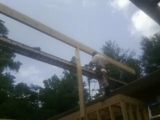 Carpenter setting a ridge beam over a new addition frame — Ice Dam Removal by Roofing Brothers in Sunol
